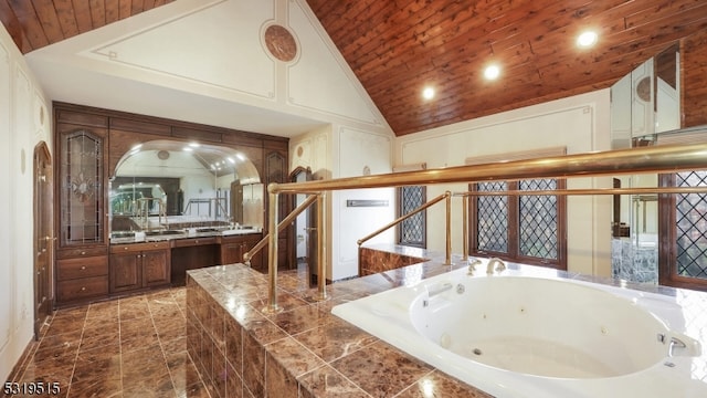 bathroom with vanity, high vaulted ceiling, and tiled tub