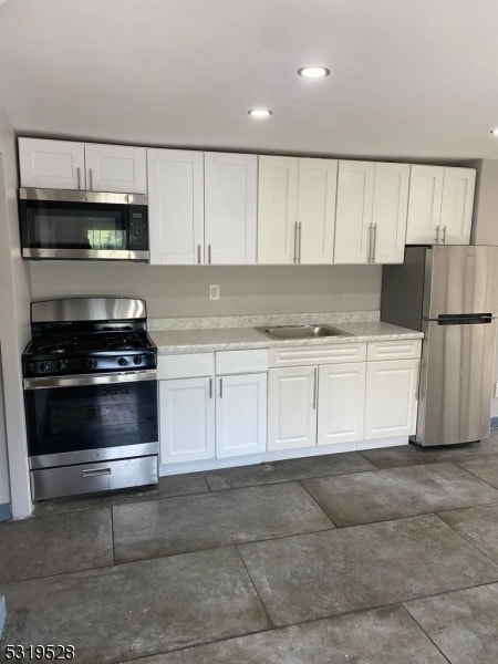 kitchen featuring sink, appliances with stainless steel finishes, and white cabinets