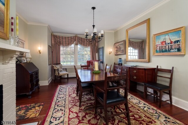 dining room with dark hardwood / wood-style flooring, crown molding, a notable chandelier, and a brick fireplace