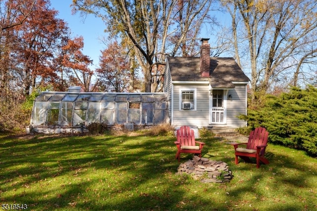 back of property featuring cooling unit and a lawn