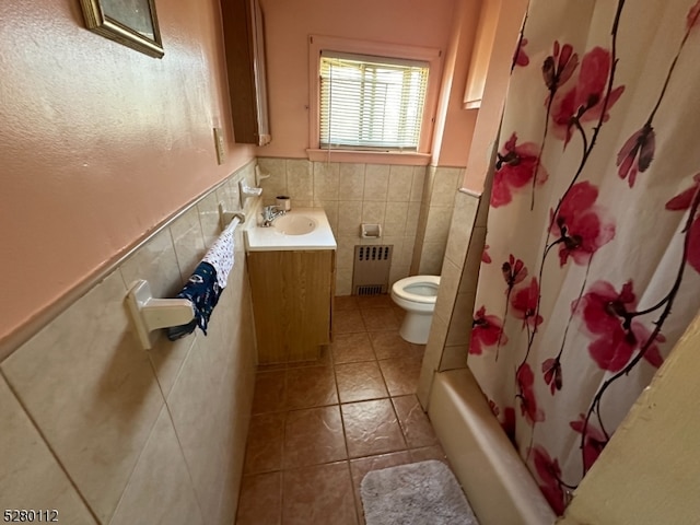 full bathroom with tile patterned floors, toilet, vanity, tile walls, and radiator heating unit