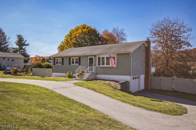 view of front of home with a front yard and a garage