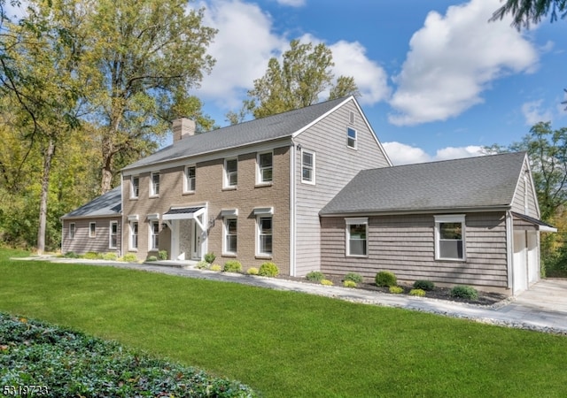 colonial inspired home featuring a front lawn and a garage