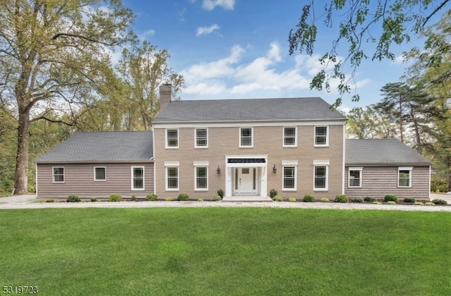 colonial house featuring a front lawn