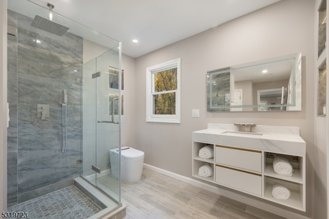 bathroom with toilet, an enclosed shower, vanity, and wood-type flooring