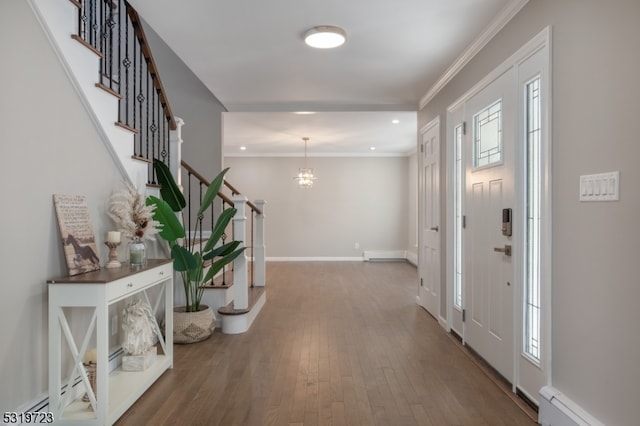 entryway featuring a baseboard radiator, hardwood / wood-style floors, a notable chandelier, and ornamental molding