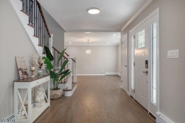 entryway with stairway, a healthy amount of sunlight, a baseboard radiator, wood finished floors, and a notable chandelier