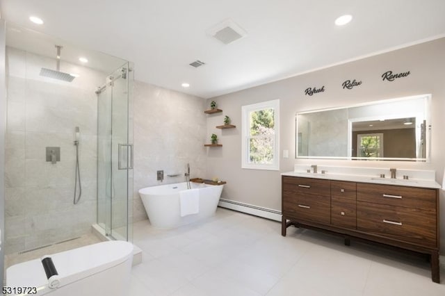 bathroom featuring a sink, a shower stall, a freestanding tub, double vanity, and a baseboard radiator
