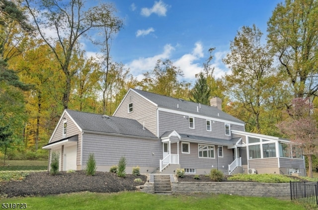 rear view of house with a garage and a sunroom