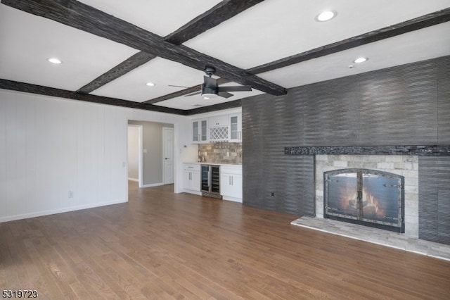 unfurnished living room featuring coffered ceiling, wine cooler, beamed ceiling, and dark wood-type flooring