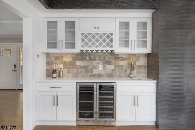bar with wet bar, a sink, backsplash, and wine cooler