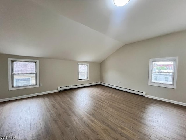 additional living space featuring lofted ceiling, baseboard heating, dark wood-style flooring, baseboards, and a baseboard radiator