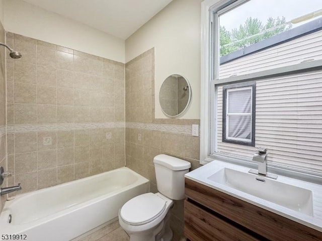 bathroom with toilet, shower / tub combination, tile walls, and vanity