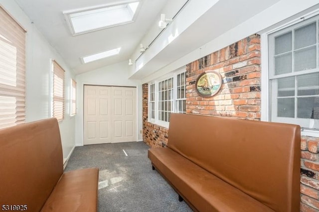 corridor with vaulted ceiling with skylight and carpet floors