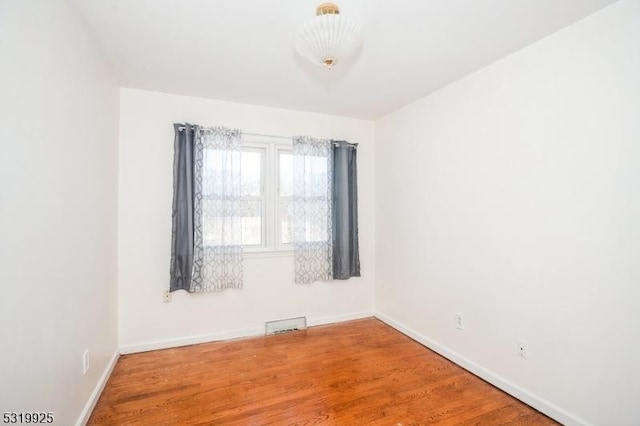 unfurnished room with wood finished floors and baseboards