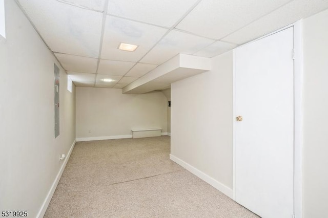 finished below grade area with baseboards, carpet flooring, and a drop ceiling