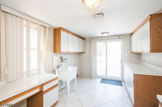 kitchen with light countertops, visible vents, a wealth of natural light, and light tile patterned floors