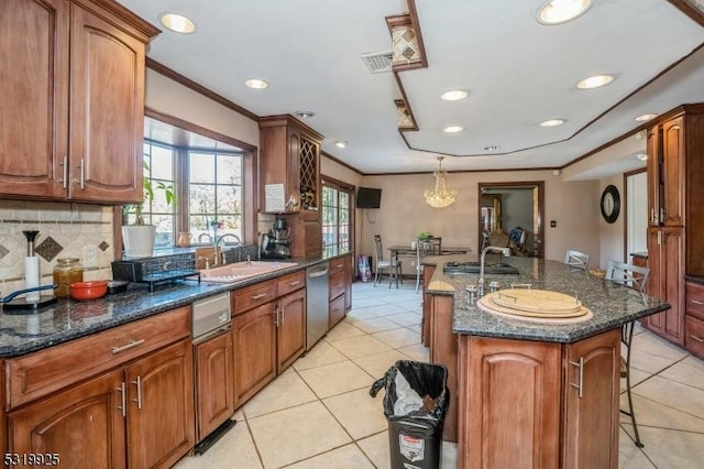 kitchen featuring a wealth of natural light, stainless steel dishwasher, a sink, and light tile patterned floors