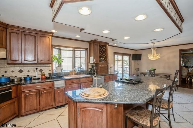 kitchen featuring a sink, a kitchen bar, light tile patterned floors, and tasteful backsplash