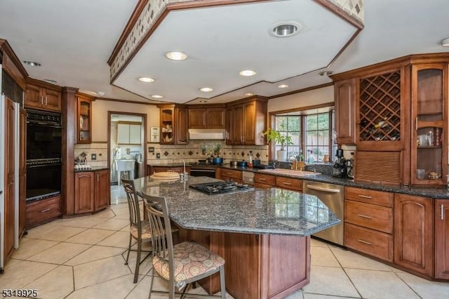 kitchen featuring stainless steel dishwasher, a sink, dobule oven black, backsplash, and light tile patterned floors