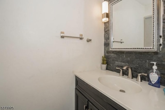 bathroom featuring vanity and tasteful backsplash