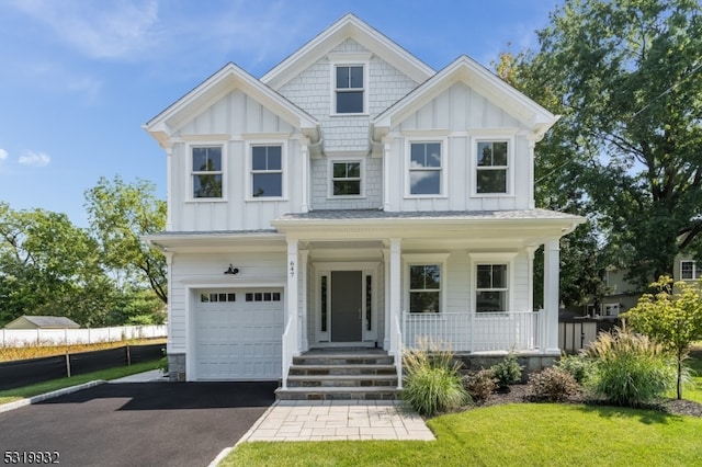 view of front facade with a porch, a front lawn, and a garage