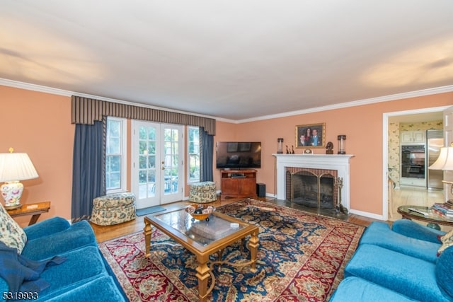 living room featuring french doors, crown molding, wood-type flooring, and a brick fireplace