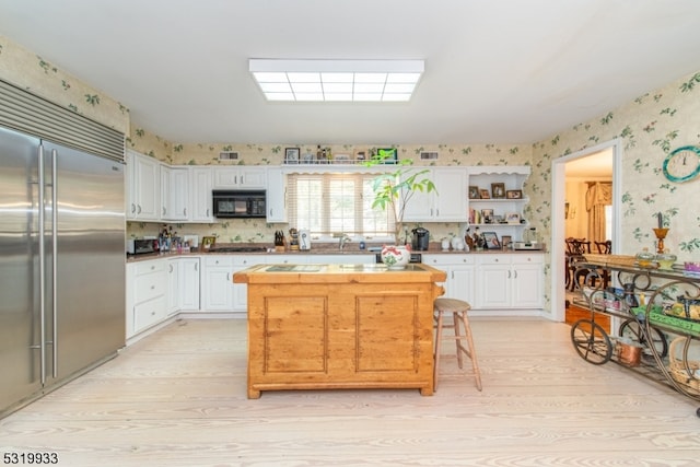 kitchen featuring built in refrigerator, white cabinets, and light hardwood / wood-style flooring