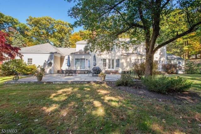 back of property with a patio and a yard