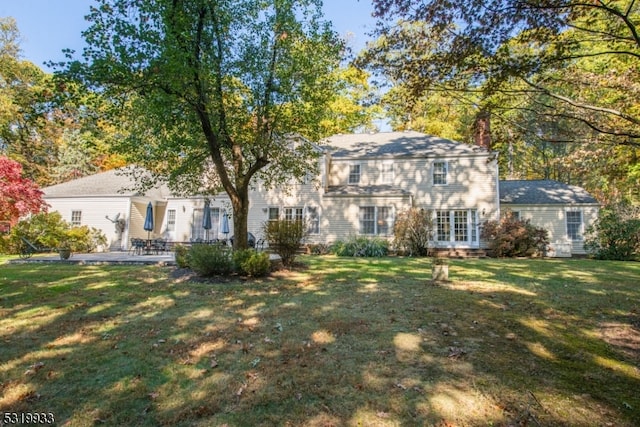 colonial home featuring a patio and a front yard