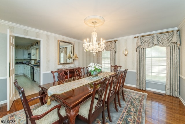 dining space featuring crown molding, a notable chandelier, and wood-type flooring