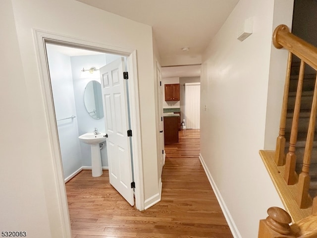 hall with sink and light wood-type flooring