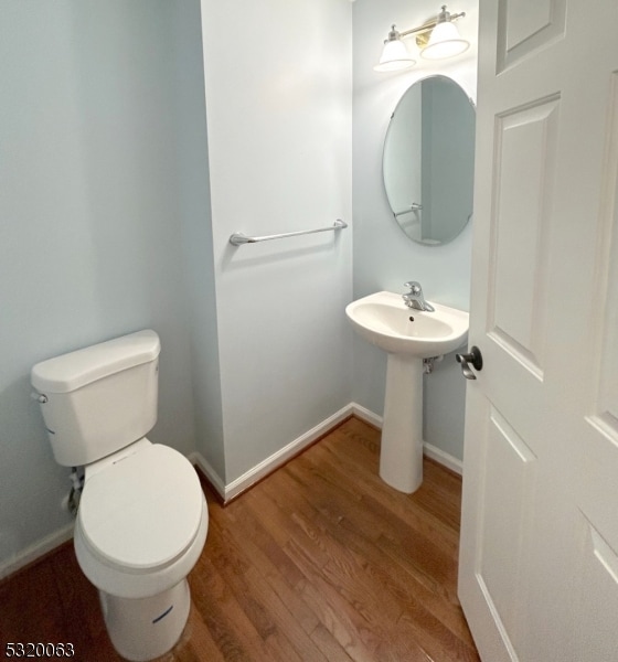 bathroom featuring wood-type flooring and toilet