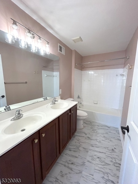 full bathroom featuring vanity, toilet, and tiled shower / bath