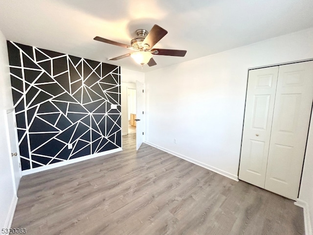 interior space with ceiling fan and wood-type flooring