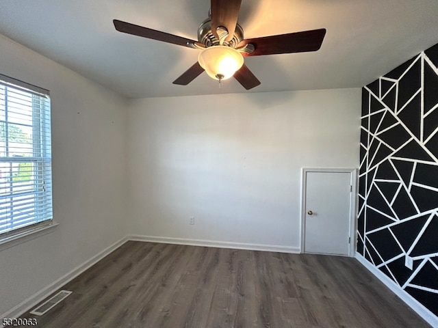 empty room featuring ceiling fan and dark hardwood / wood-style flooring