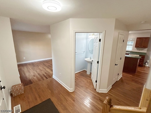 hallway with sink and light wood-type flooring