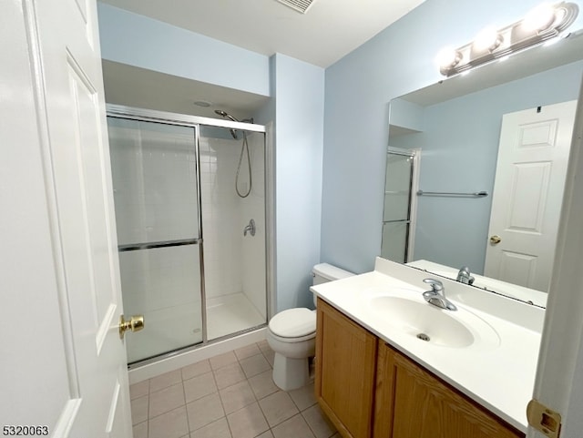 bathroom featuring toilet, tile patterned flooring, vanity, and a shower with door