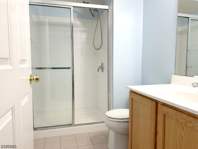 bathroom featuring a shower with door, vanity, and toilet