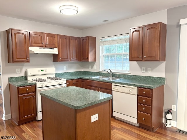 kitchen featuring a kitchen island, sink, dark wood-type flooring, and white appliances