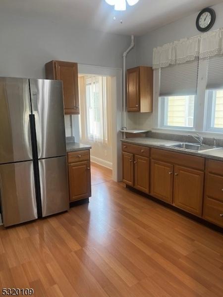 kitchen featuring a healthy amount of sunlight, light wood-type flooring, sink, and stainless steel refrigerator