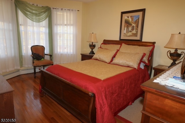 bedroom featuring a baseboard radiator and dark hardwood / wood-style flooring