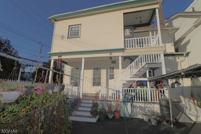 rear view of house featuring covered porch