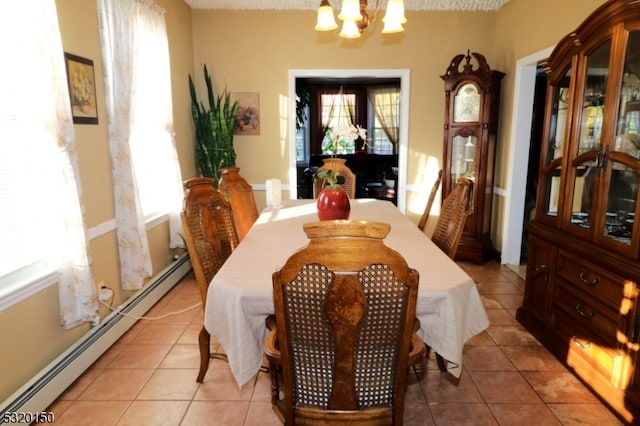 tiled dining room featuring a baseboard radiator, a textured ceiling, and an inviting chandelier