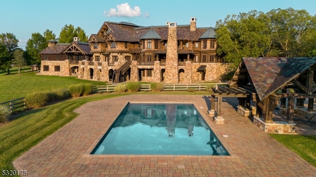 view of swimming pool featuring a patio area and a yard