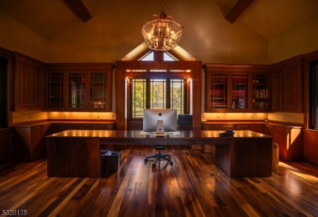 home office with built in desk, dark hardwood / wood-style flooring, a chandelier, high vaulted ceiling, and beamed ceiling