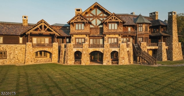 view of front of home with a balcony and a front yard