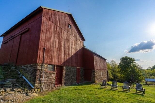 back of house featuring an outdoor structure and a yard