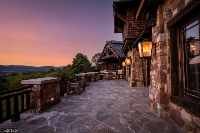 patio terrace at dusk featuring a mountain view