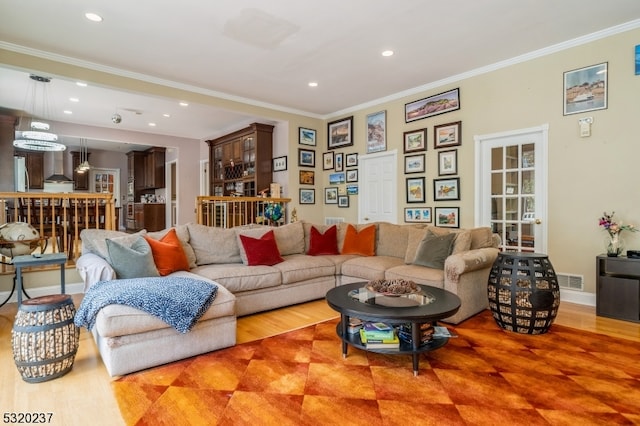 living room with wood-type flooring and ornamental molding